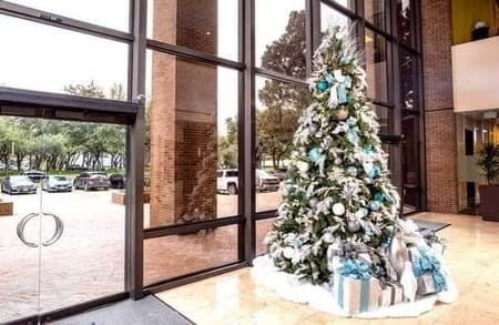 Blue and gold Christmas tree with presents under tree in an office building 