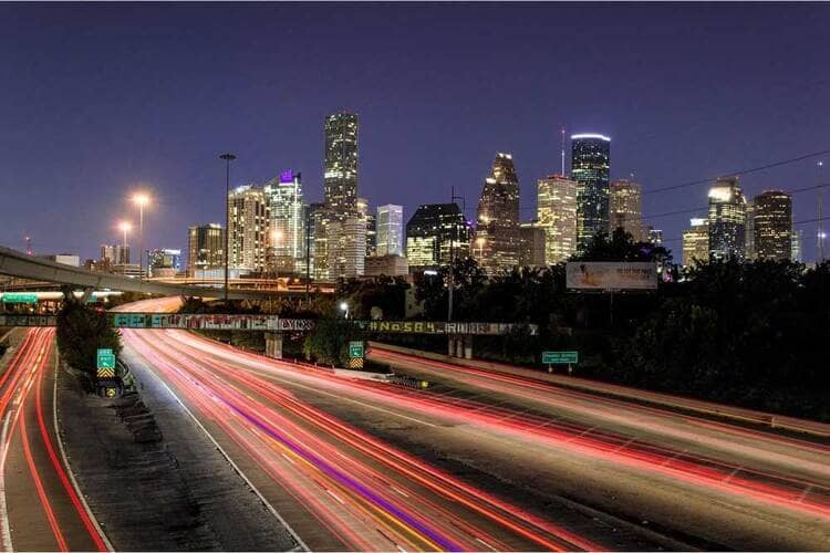 Evening lights of Huston highway with cars and buildings 
